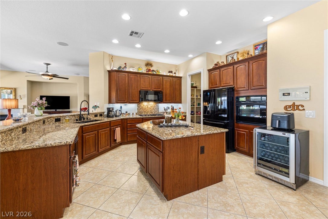 2107 Noah Tyler Ct., Henderson, NV 89052 Rich wood cabinetry and expansive granite countertops define this classic, open culinary space.