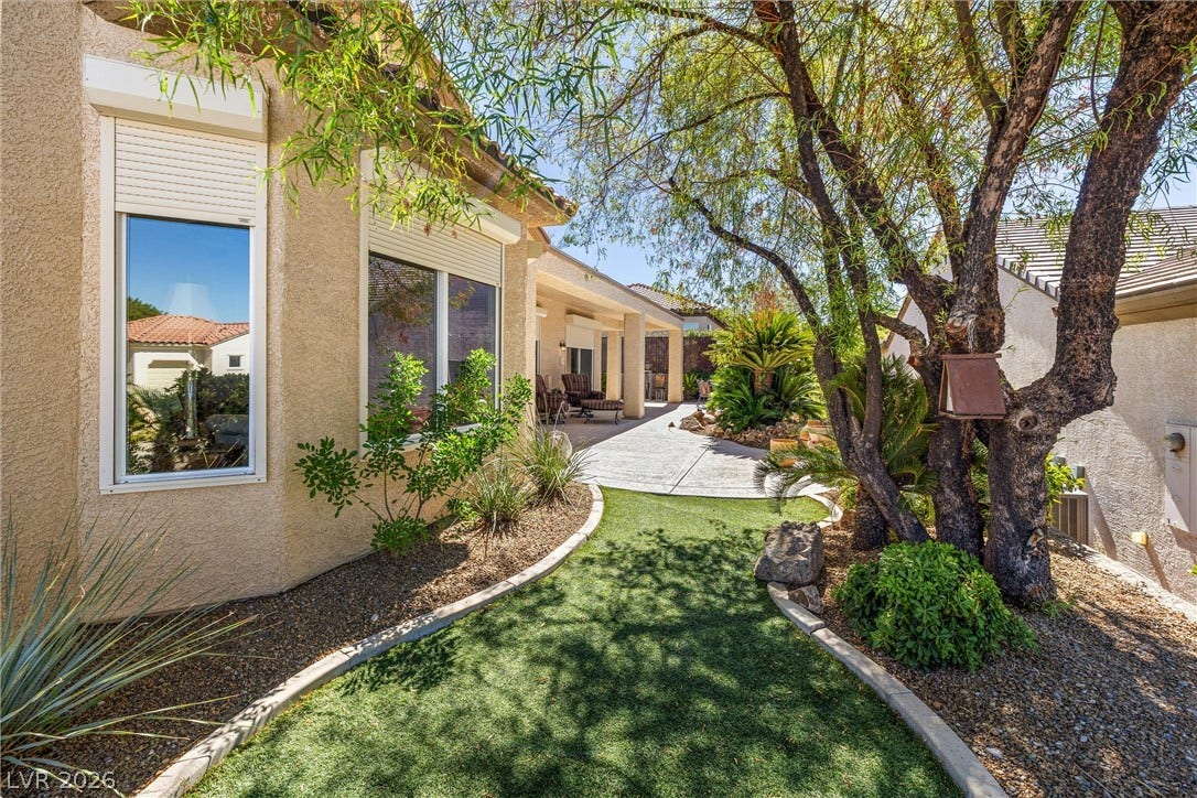 2107 Noah Tyler Ct., Henderson, NV 89052 Mature trees shade a tidy curved lawn leading toward the covered back patio.