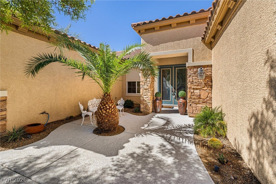 2107 Noah Tyler Ct., Henderson, NV 89052 An inviting gated entry courtyard with stone accents and a palm tree welcomes visitors.
