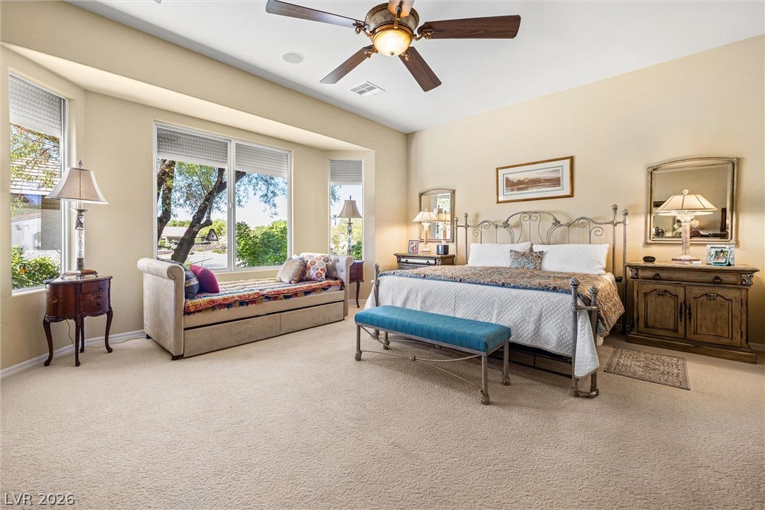 2107 Noah Tyler Ct., Henderson, NV 89052 Broad windows draw abundant natural light into this spacious primary bedroom with soft carpeting.