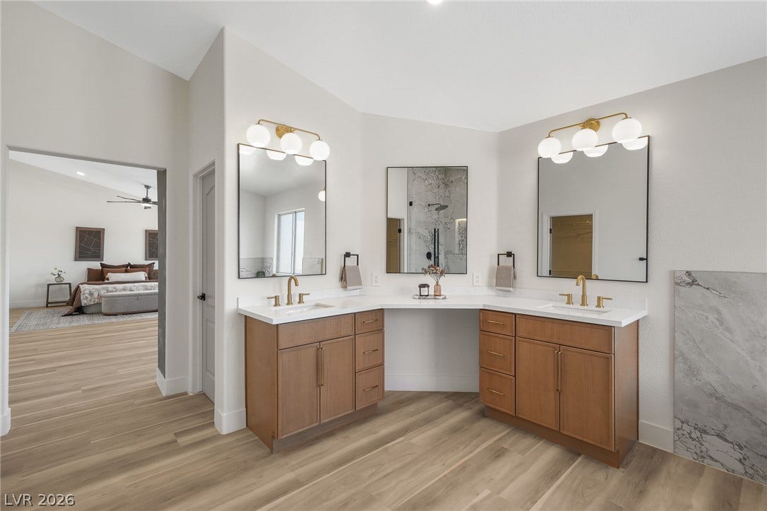 1287 Lime Point Street, Las Vegas, NV 89110 Angled double vanities and warm wood flooring define this elegant primary bathroom.