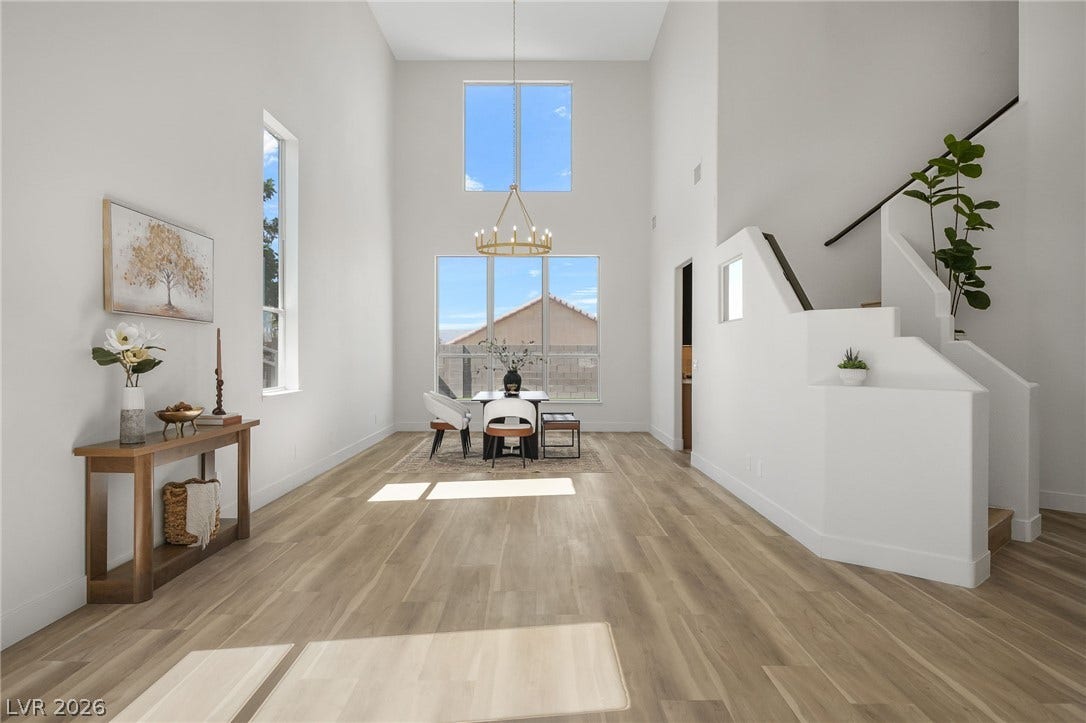 1287 Lime Point Street, Las Vegas, NV 89110 Double-height ceilings and tall windows illuminate the open-concept living area with handsome wood flooring.