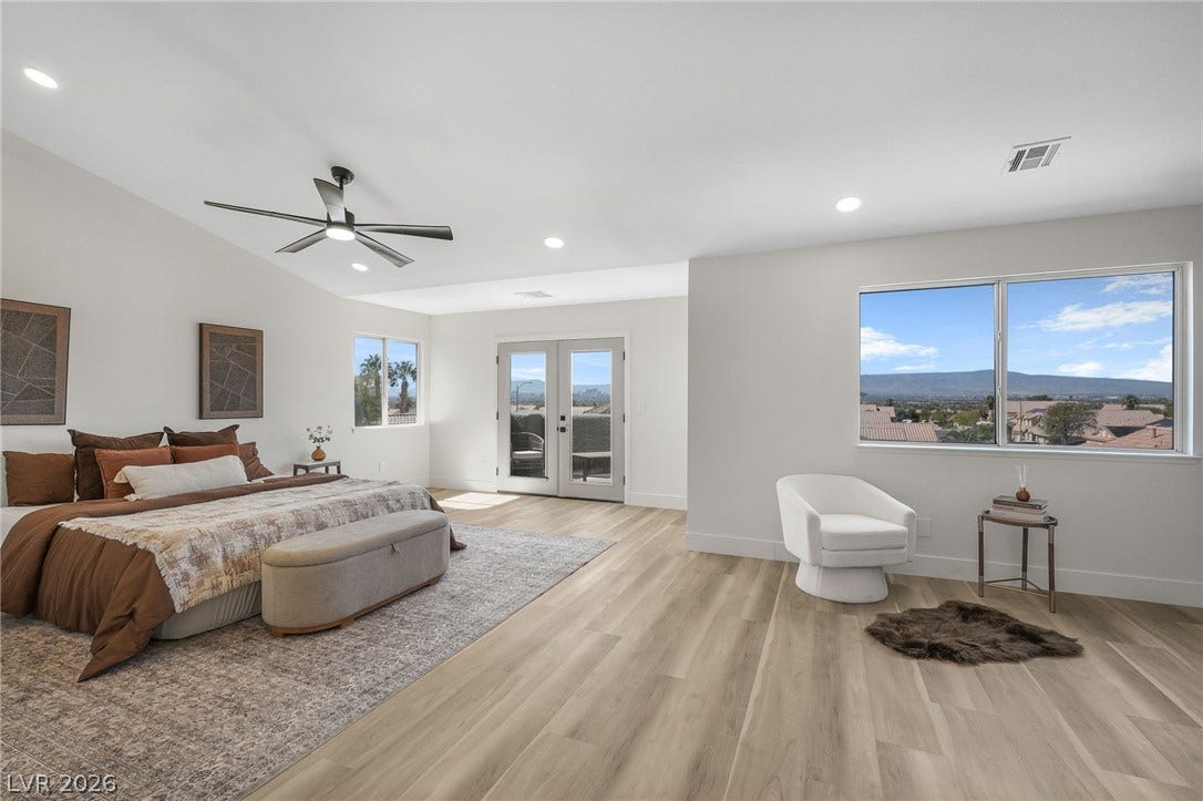 1287 Lime Point Street, Las Vegas, NV 89110 A spacious bedroom features warm wood flooring and large windows looking out to distant mountains.