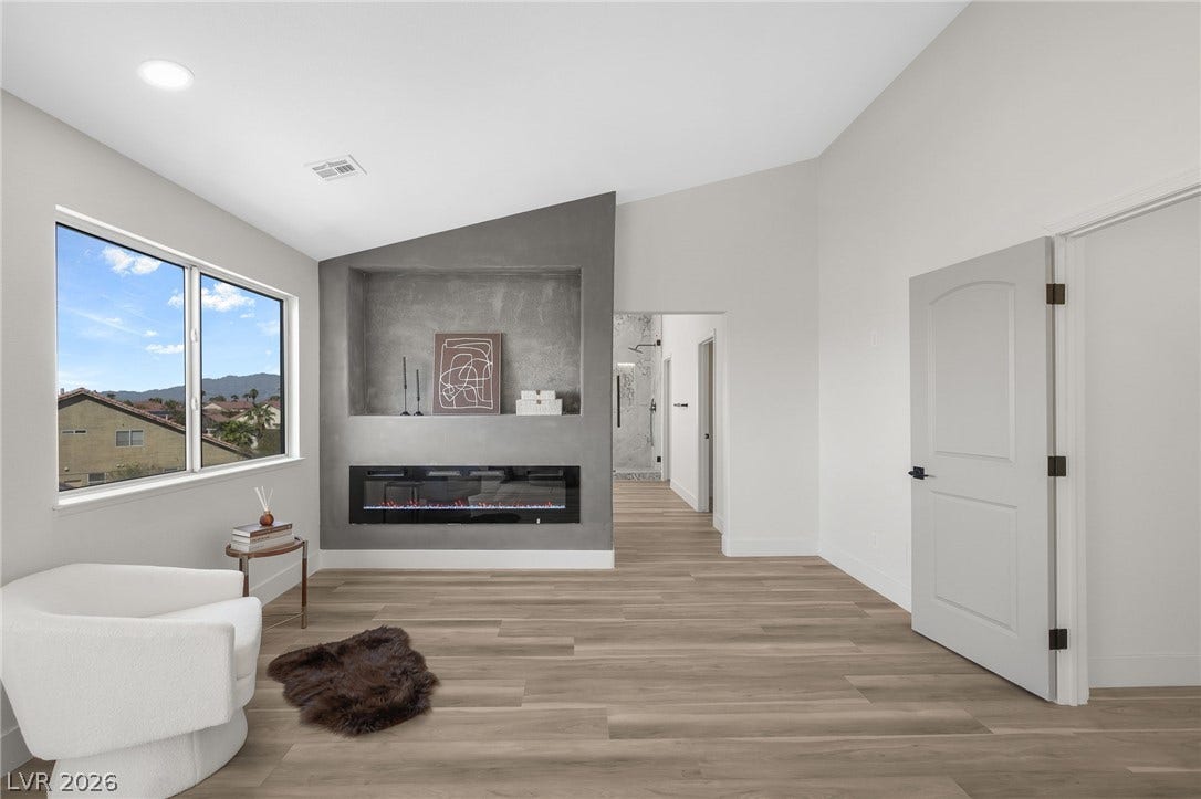 1287 Lime Point Street, Las Vegas, NV 89110 An elegant modern fireplace sits beneath vaulted ceilings and warm wood flooring.