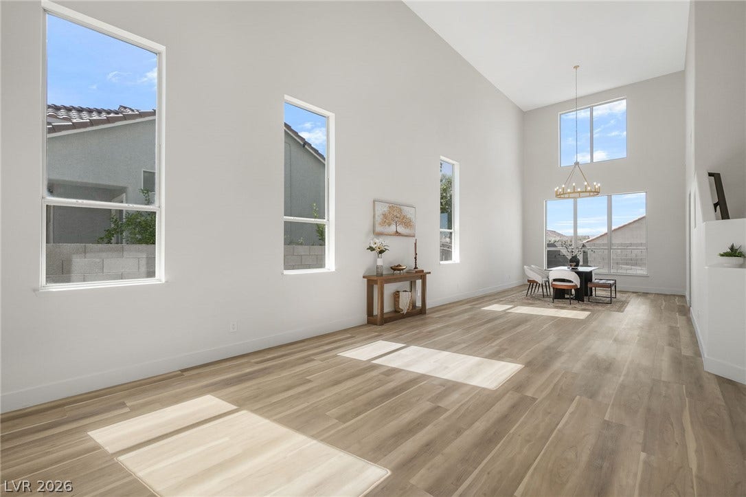 1287 Lime Point Street, Las Vegas, NV 89110 High vaulted ceilings and rich wood-style flooring elevate this light-filled open main living space.