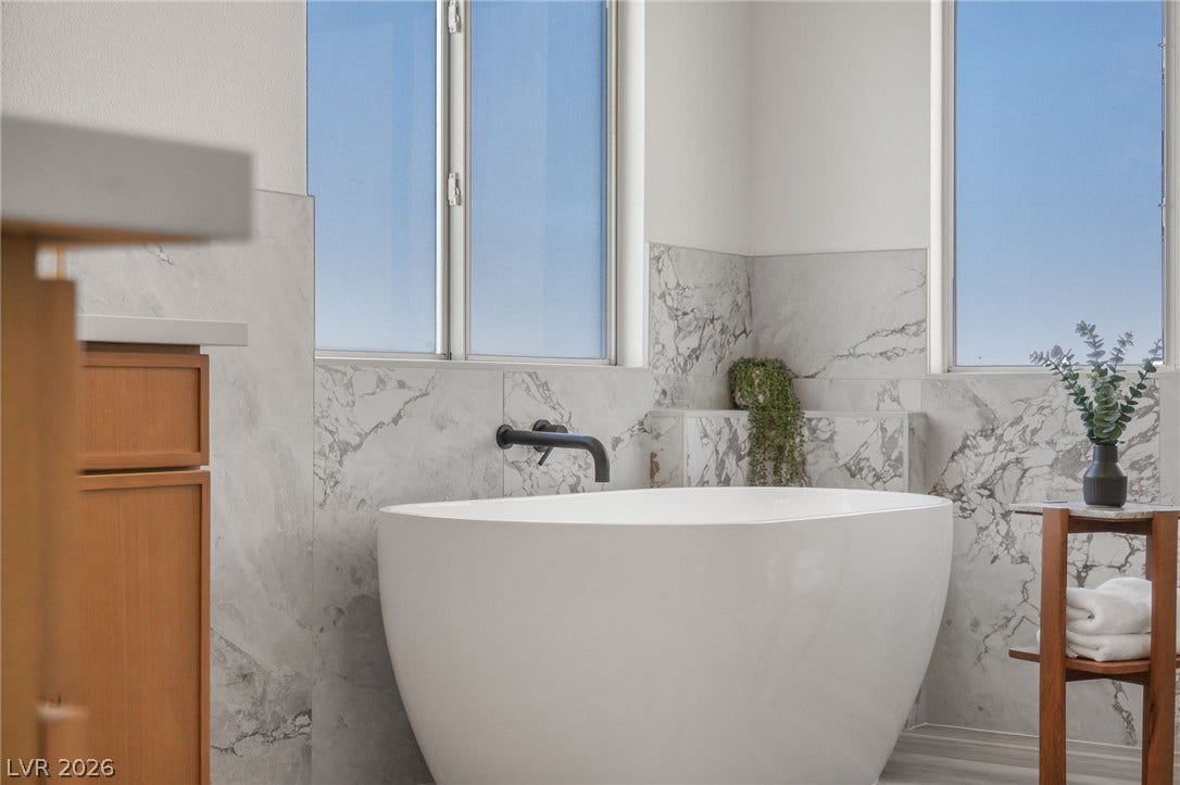 1287 Lime Point Street, Las Vegas, NV 89110 Marble wall tiles and a freestanding tub define this serene bathing space.