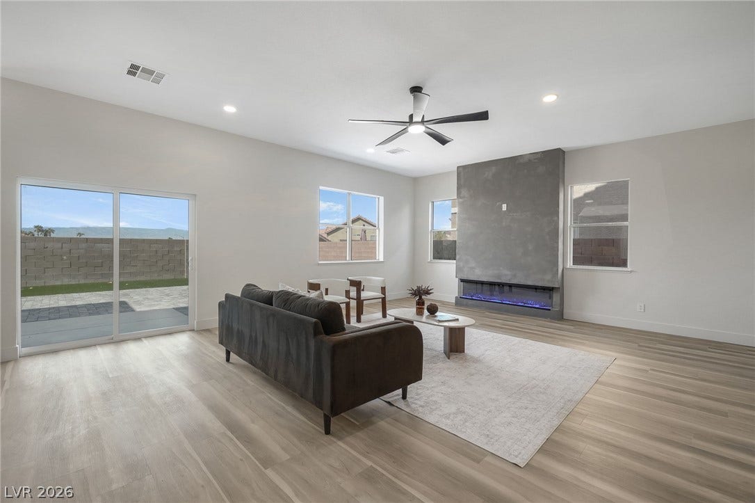 1287 Lime Point Street, Las Vegas, NV 89110 An integrated fireplace accents this airy main level gathering space highlighted by wood-patterned flooring.