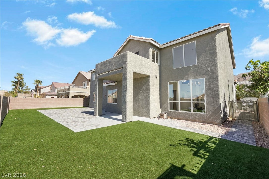 1287 Lime Point Street, Las Vegas, NV 89110 A spacious backyard showcases a manicured lawn alongside low-maintenance desert stucco architecture.