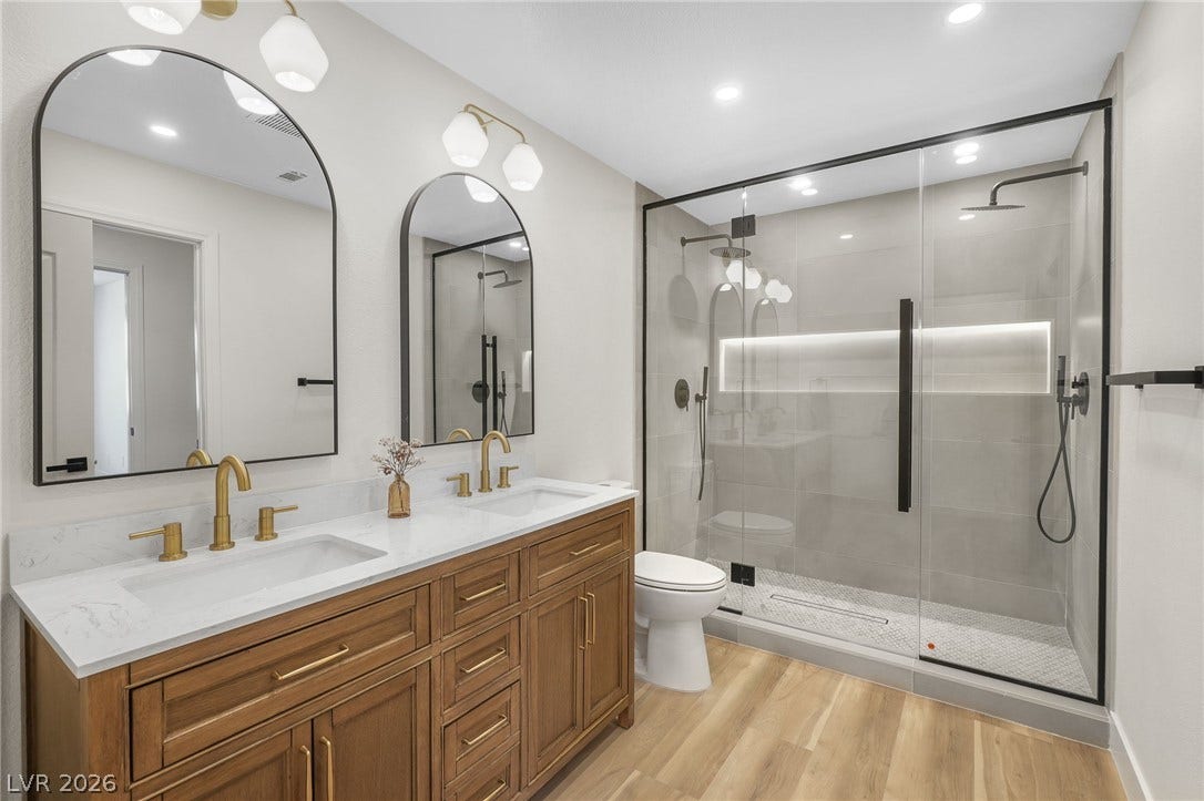 1287 Lime Point Street, Las Vegas, NV 89110 Gold fixtures complement a double vanity and sleek glass shower in this modern bathroom.