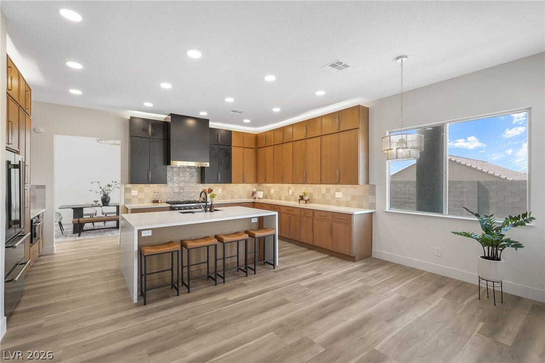 1287 Lime Point Street, Las Vegas, NV 89110 Warm wood cabinetry and an expansive central island anchor this modern open-concept culinary space.