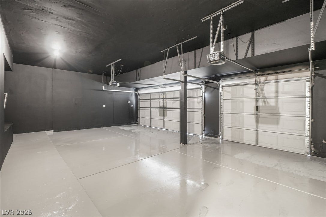 1287 Lime Point Street, Las Vegas, NV 89110 Smooth concrete floors and sleek dark walls define this expansive multi-car garage space.