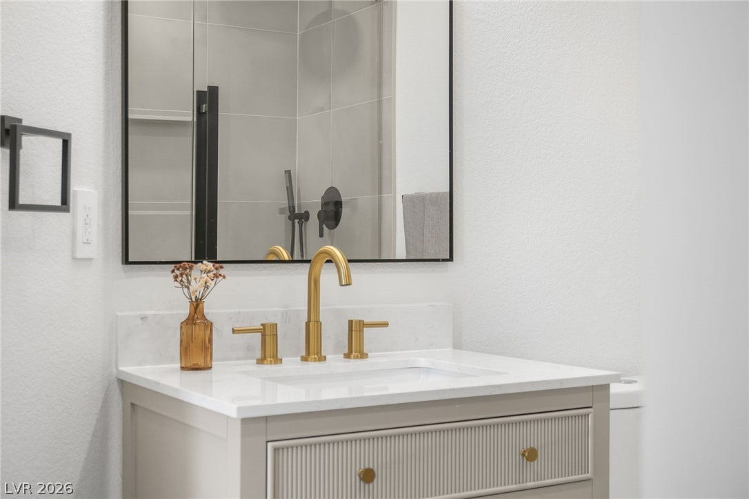 1287 Lime Point Street, Las Vegas, NV 89110 Elegant gold hardware pairs beautifully with stone counters in this sleek bathroom design.