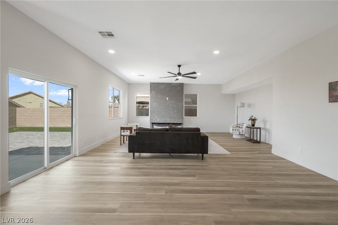 1287 Lime Point Street, Las Vegas, NV 89110 Smooth wood floors anchor this open living area featuring sliding glass doors and high ceilings.