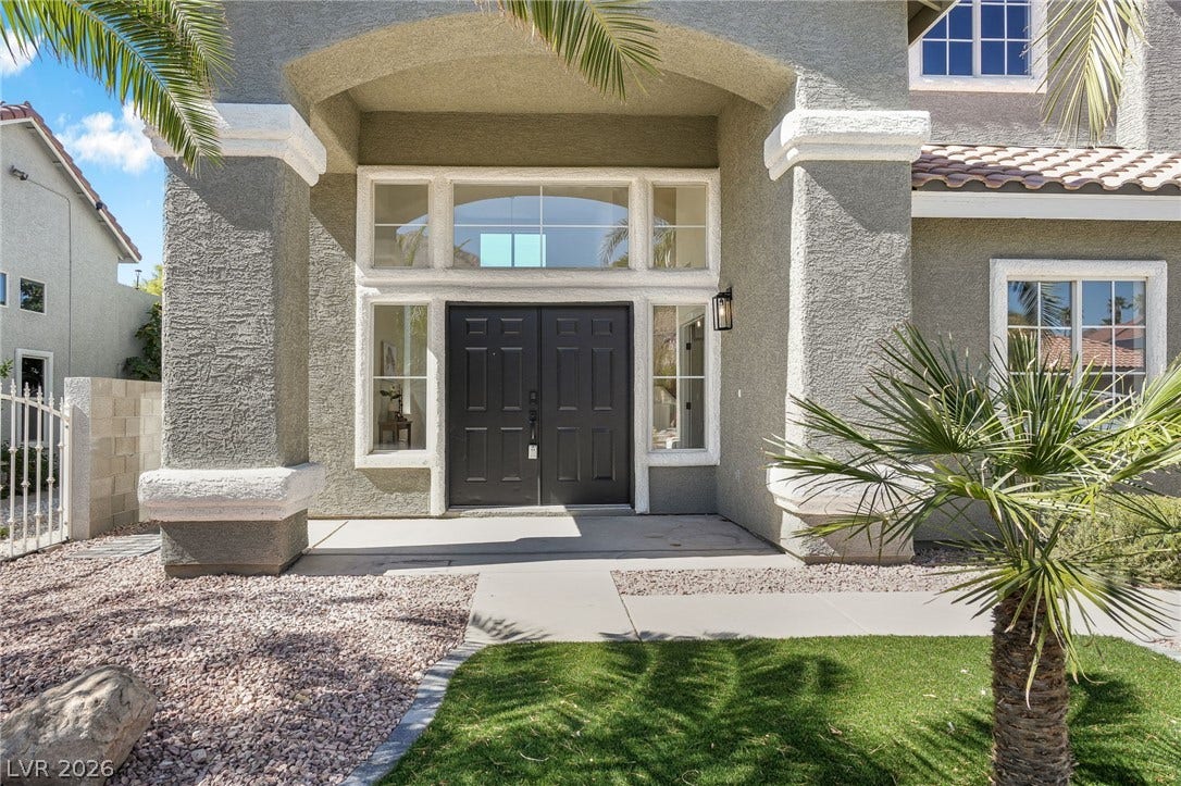 1287 Lime Point Street, Las Vegas, NV 89110 Bold double doors beneath a grand arched entryway create an impressive architectural statement.