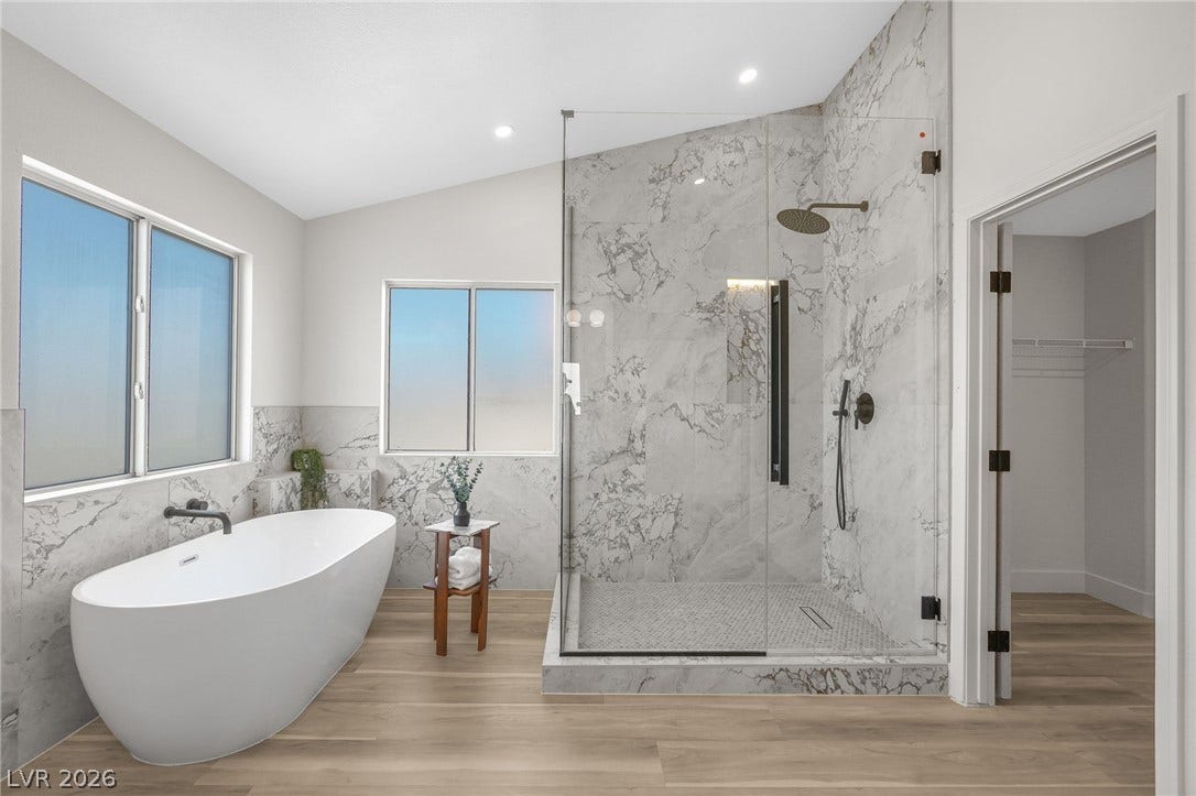 1287 Lime Point Street, Las Vegas, NV 89110 Vaulted ceilings and wood-look flooring enhance this primary bath featuring a custom tile shower.