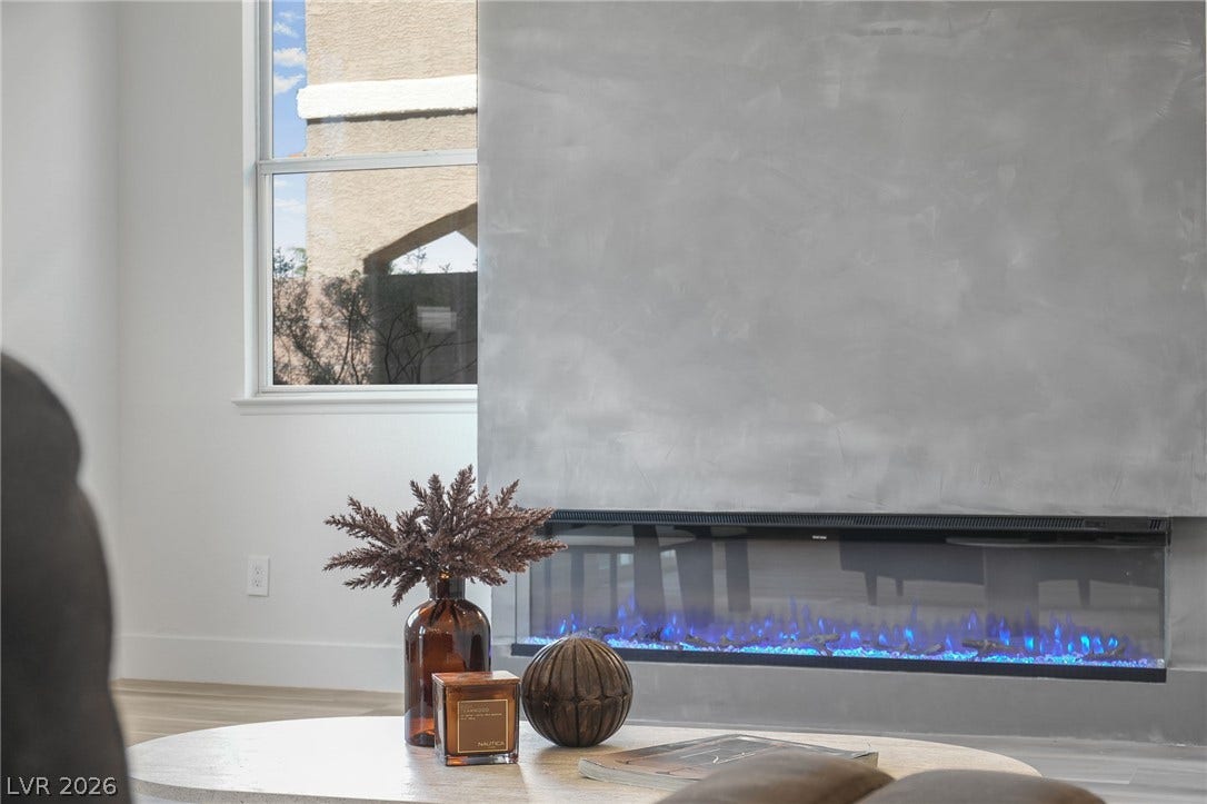 1287 Lime Point Street, Las Vegas, NV 89110 A modern linear fireplace anchors the room with a sleek, minimalist plaster finish.
