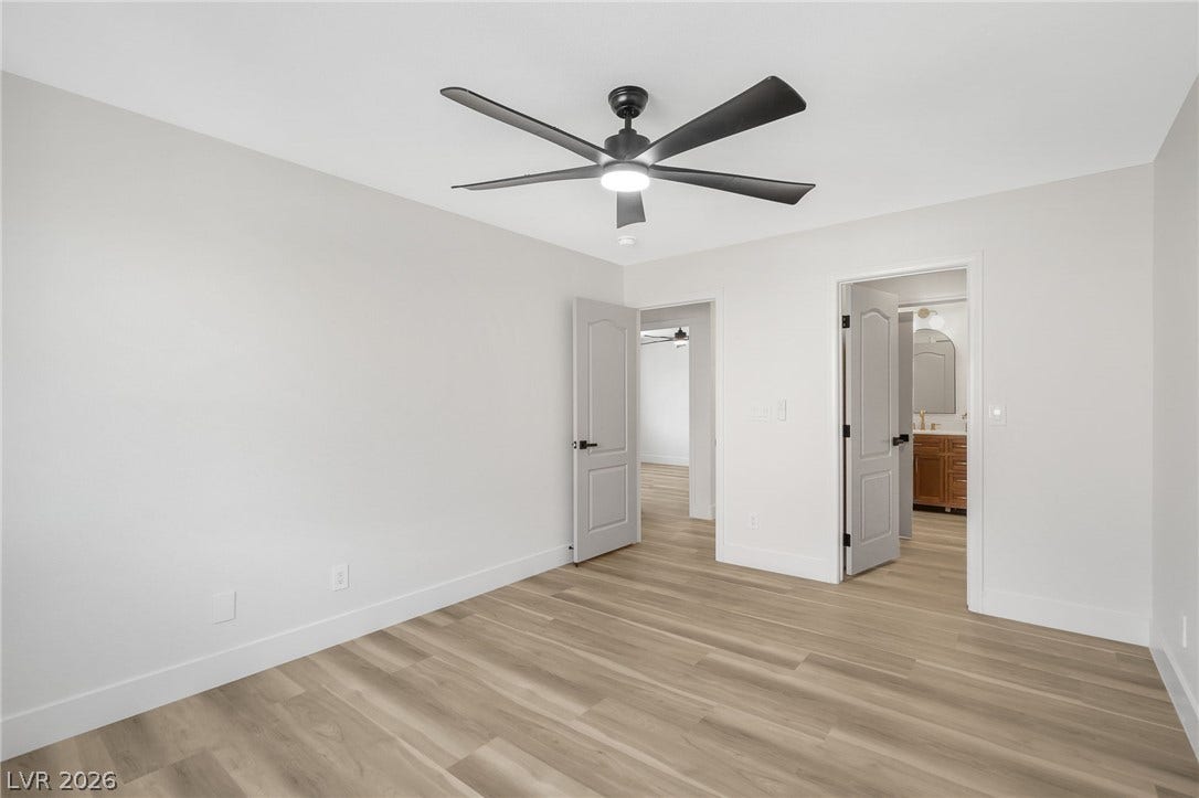 1287 Lime Point Street, Las Vegas, NV 89110 A crisp white bedroom features light wood floors and smooth walls under clean ceiling transitions.