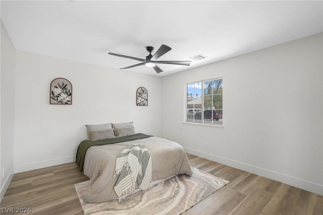 1287 Lime Point Street, Las Vegas, NV 89110 Smooth wood-style flooring and a wide window create a comfortable, airy atmosphere in this bedroom.