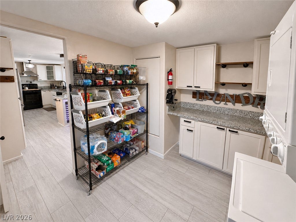 6130 Hawkins Way, Pahrump, NV 89061 Functional utility space features durable stone counters and seamless light-toned plank flooring.