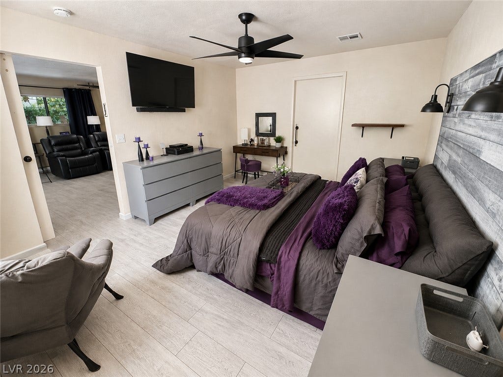 6130 Hawkins Way, Pahrump, NV 89061 Plank flooring runs throughout this spacious bedroom with an adjoining living area.
