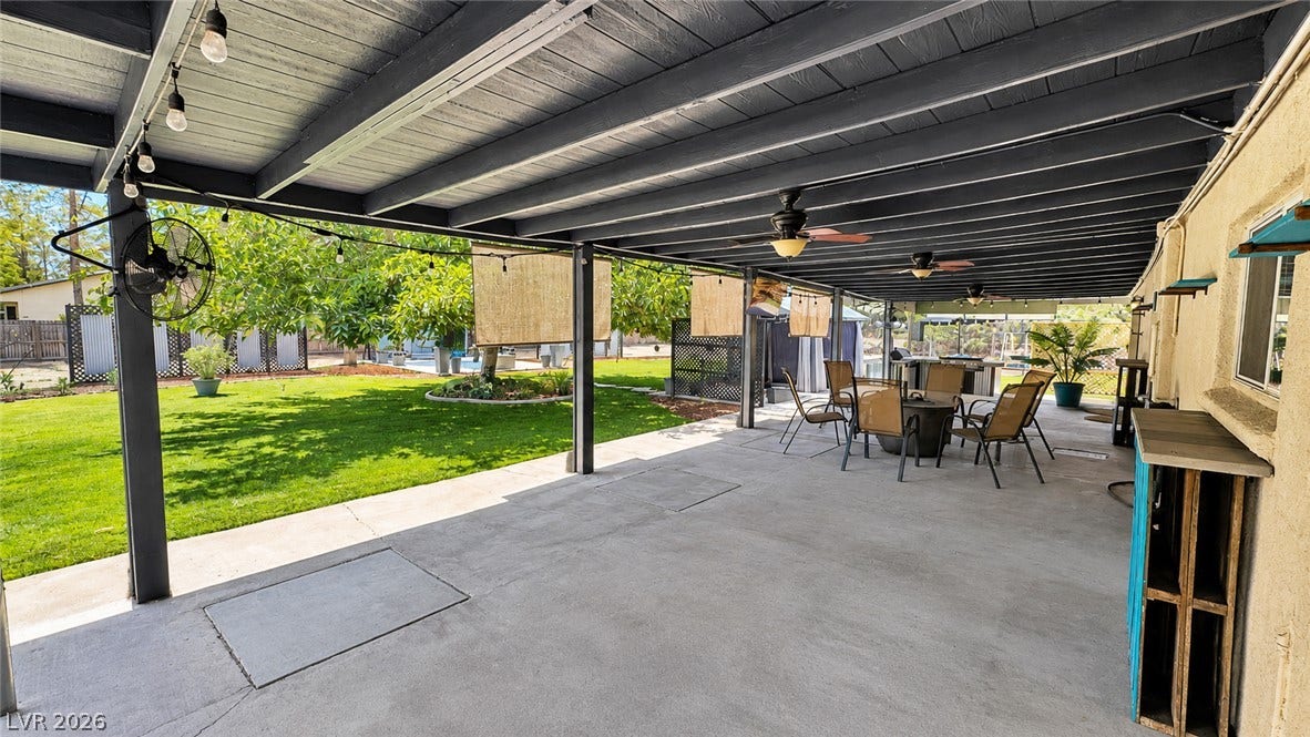 6130 Hawkins Way, Pahrump, NV 89061 An expansive covered concrete patio looks out onto a manicured green lawn.