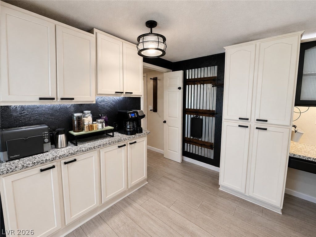 6130 Hawkins Way, Pahrump, NV 89061 Gleaming stone countertops and classic cabinetry elevate this updated kitchen workspace.