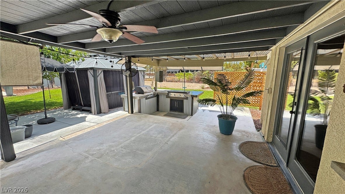 6130 Hawkins Way, Pahrump, NV 89061 A spacious covered patio leads directly to the built-in outdoor kitchen and grassy yard.