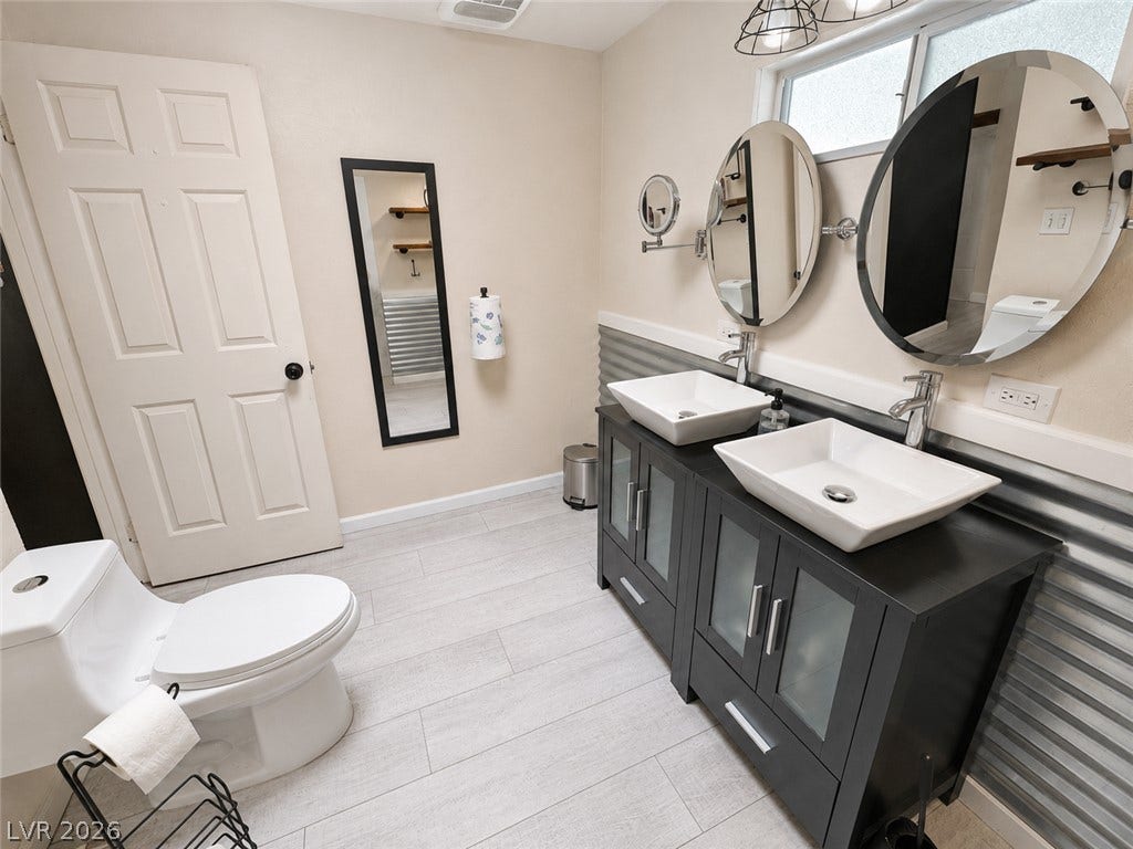 6130 Hawkins Way, Pahrump, NV 89061 Clean lines and a modern double vanity define this well-appointed bathroom space.