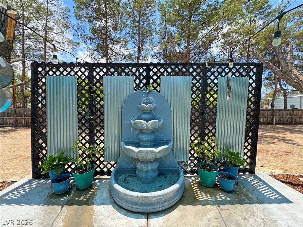 6130 Hawkins Way, Pahrump, NV 89061 A tiered outdoor water fountain stands centered against a decorative lattice screen backdrop.