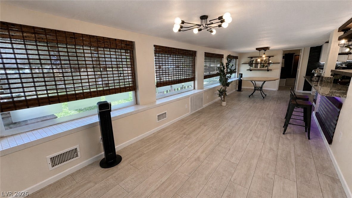 6130 Hawkins Way, Pahrump, NV 89061 A long wall of windows and durable plank flooring define this versatile main living area.
