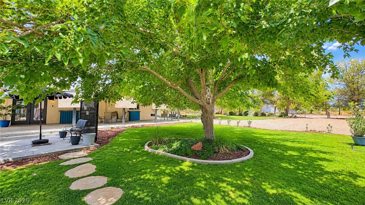 6130 Hawkins Way, Pahrump, NV 89061 Mature shade trees and a stone pathway define this lush, landscaped lawn.