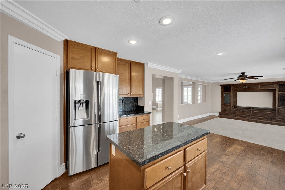 10149 Whitney Falls Court, Las Vegas, NV 89148 An open kitchen layout transitions smoothly into a comfortable living area with warm wood flooring.