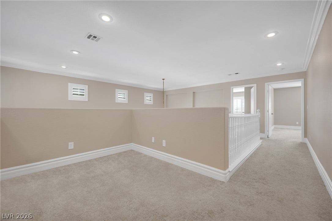 10149 Whitney Falls Court, Las Vegas, NV 89148 Plush carpeting and classic crown molding accent this versatile upper-level landing space.