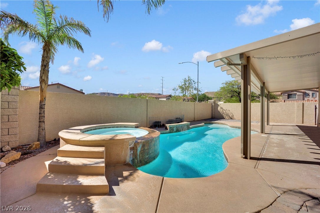 10149 Whitney Falls Court, Las Vegas, NV 89148 An inviting backyard oasis features a shimmering swimming pool alongside an elevated, integrated spa.