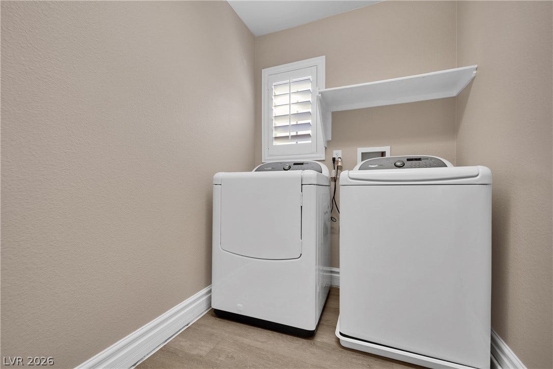 10149 Whitney Falls Court, Las Vegas, NV 89148 Functional laundry space features wood-style flooring and a built-in overhead shelf.
