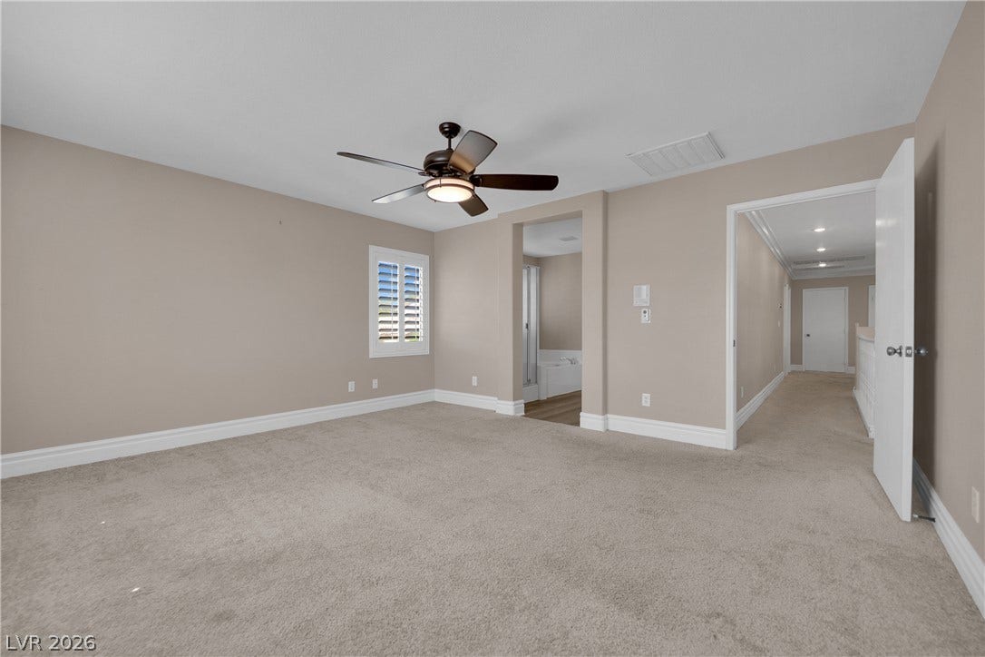 10149 Whitney Falls Court, Las Vegas, NV 89148 Plush carpeting and plantation shutters define this serene bedroom space with an attached bath.