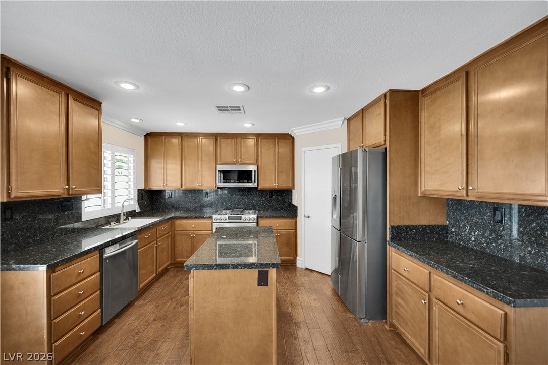 10149 Whitney Falls Court, Las Vegas, NV 89148 Gleaming wood flooring and stone countertops anchor this classic kitchen design.
