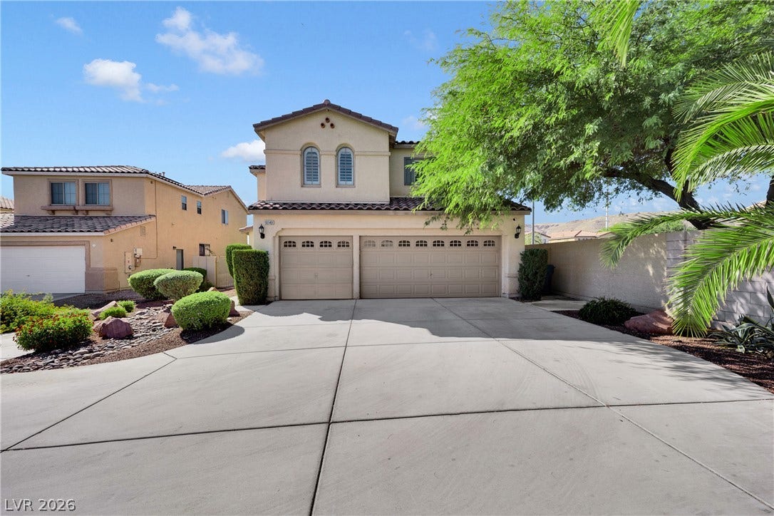 10149 Whitney Falls Court, Las Vegas, NV 89148 An expansive concrete driveway leads to the multi-car garage of this stucco-finished home.