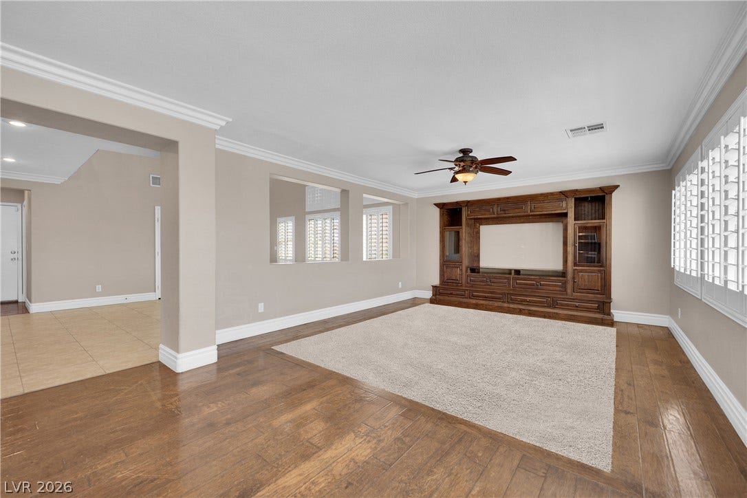 10149 Whitney Falls Court, Las Vegas, NV 89148 Rich hardwood flooring and classic crown molding anchor this open, versatile living space.