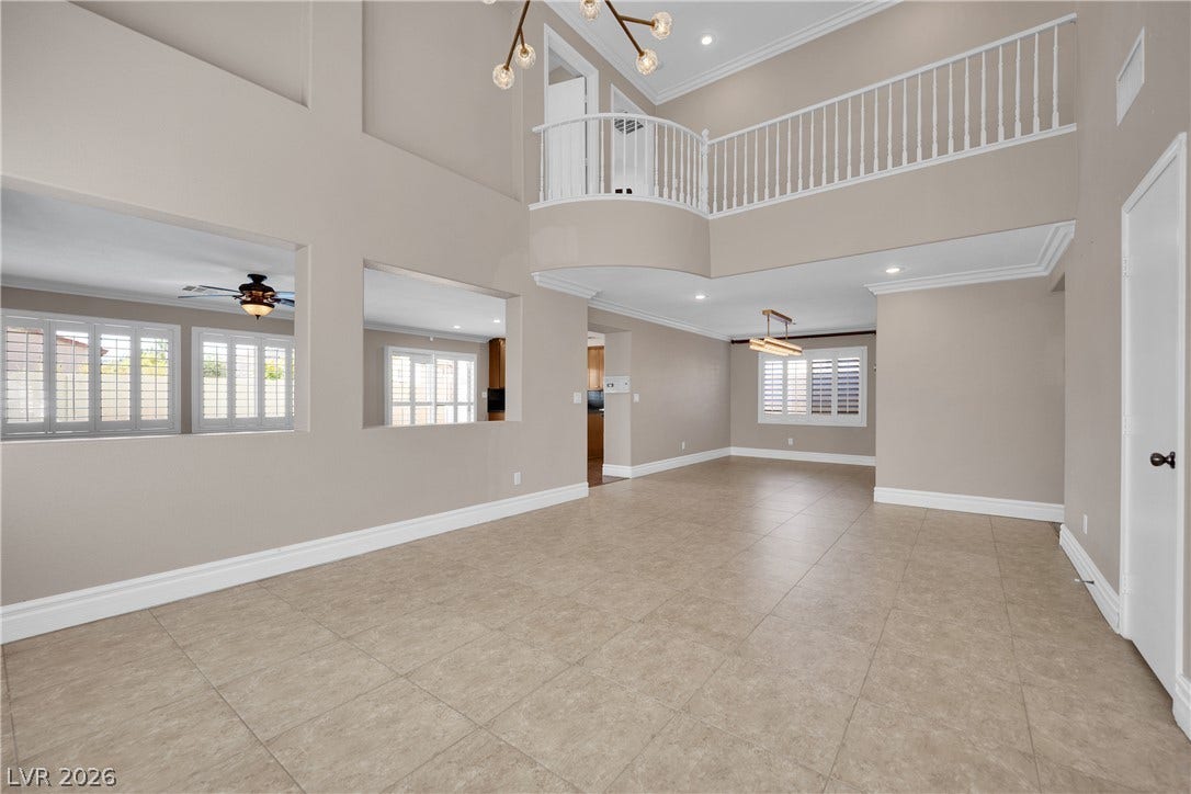 10149 Whitney Falls Court, Las Vegas, NV 89148 An open floor plan with tile flooring, soaring ceilings, and a overlooking second-story balcony.