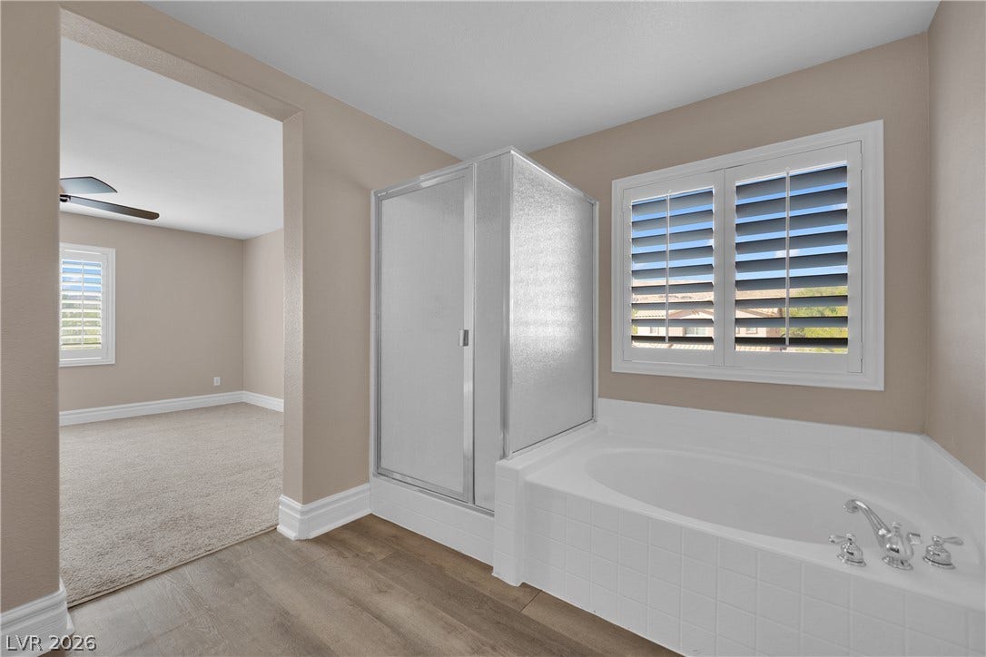 10149 Whitney Falls Court, Las Vegas, NV 89148 A spacious soaking tub sits beneath a shuttered window adjacent to the walk-in shower.