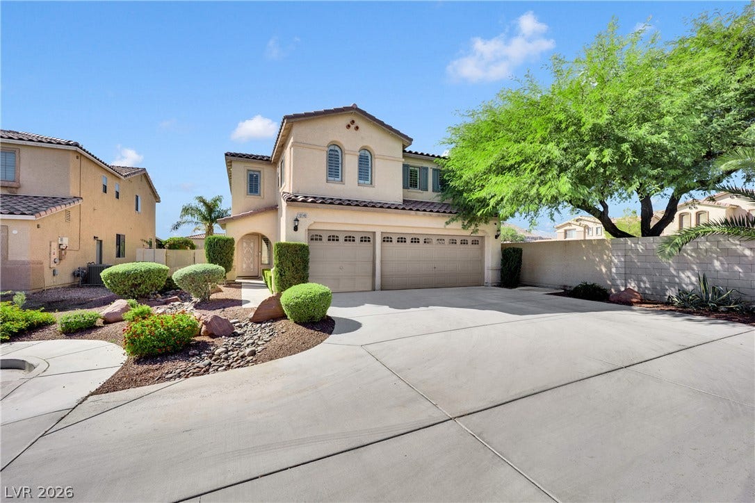 10149 Whitney Falls Court, Las Vegas, NV 89148 A spacious driveway leads to this classic Mediterranean-style home under clear blue skies.