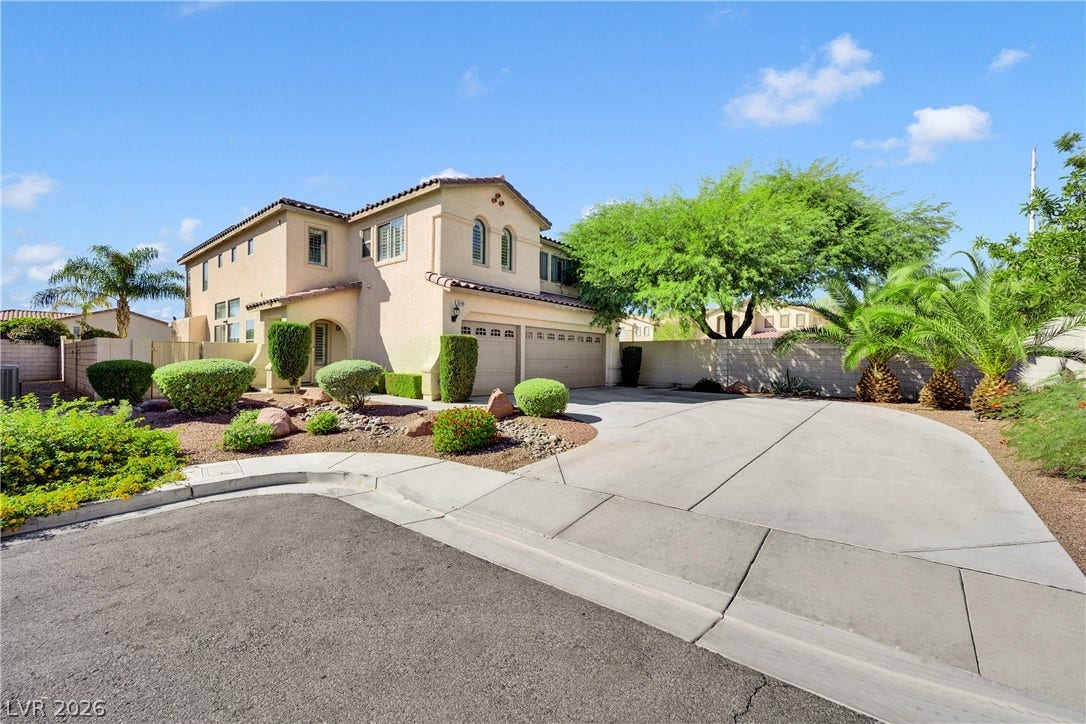 10149 Whitney Falls Court, Las Vegas, NV 89148 An expansive concrete driveway leads to a classic stucco exterior under a tile roof.