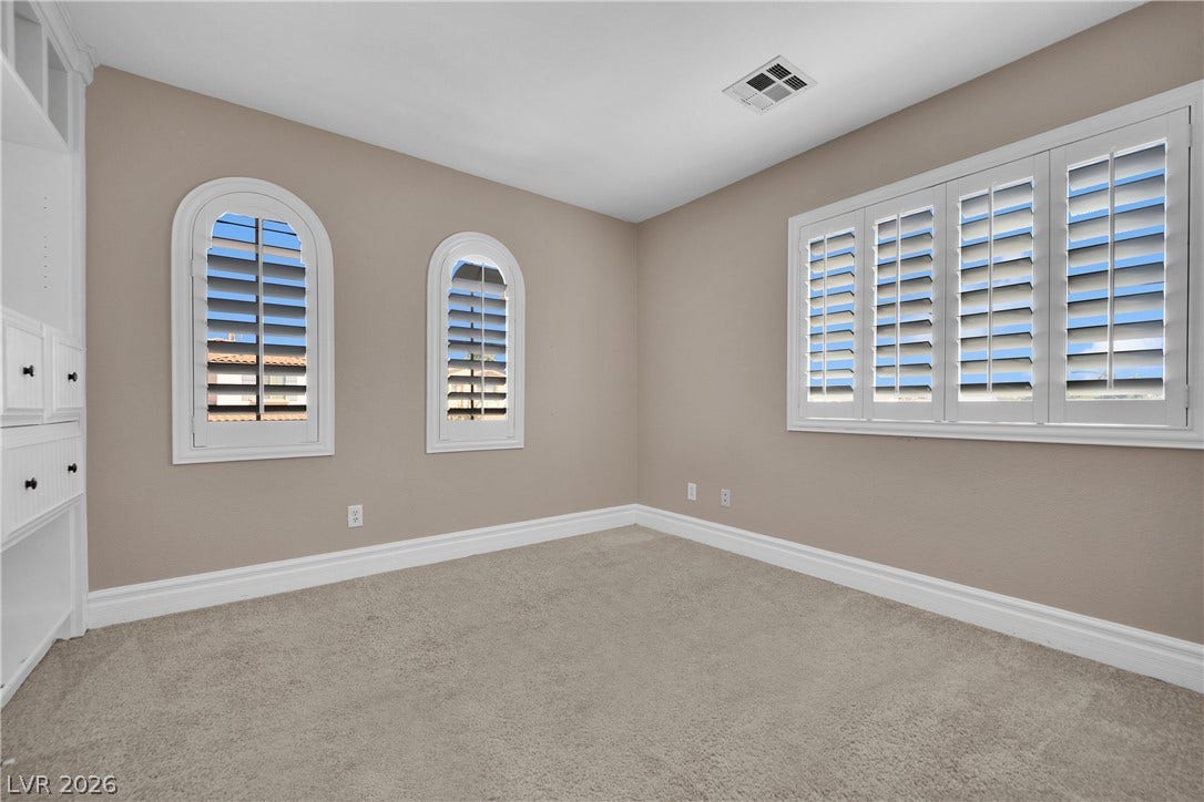 10149 Whitney Falls Court, Las Vegas, NV 89148 Arched windows and elegant plantation shutters define this versatile carpeted space.