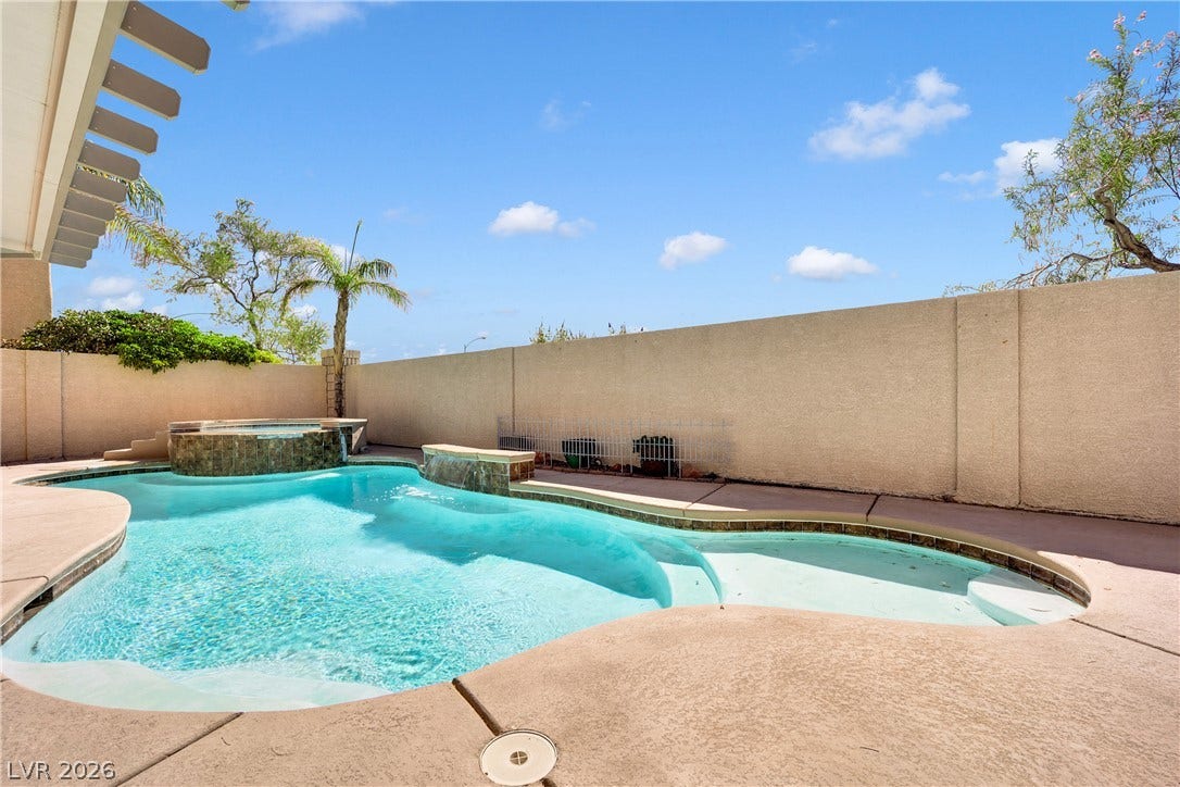 10149 Whitney Falls Court, Las Vegas, NV 89148 An inviting backyard oasis features a custom swimming pool and spa surrounded by privacy walls.