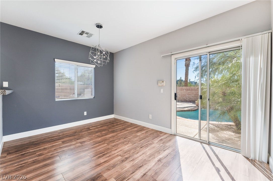 2825 Woodland Park Avenue, North Las Vegas, NV 89086 Rich wood-look flooring and sliding glass doors open directly to the sparkling backyard pool.