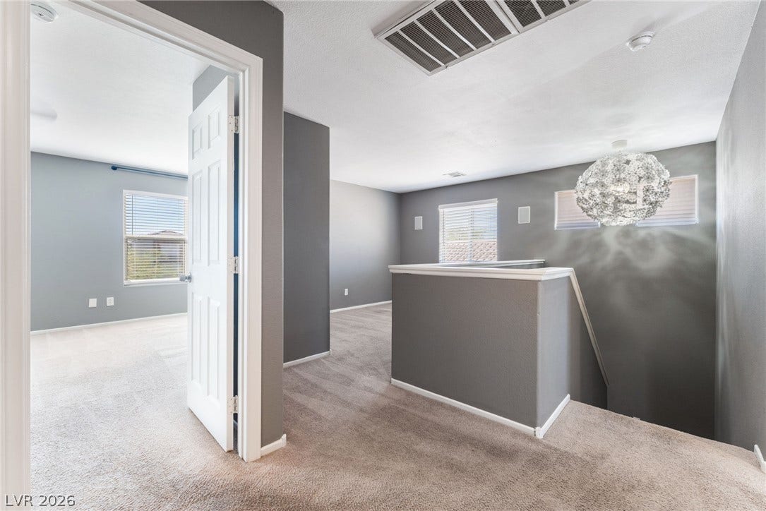 2825 Woodland Park Avenue, North Las Vegas, NV 89086 Plush carpeting and an architectural stairway landing create a welcoming upper-level transition space.