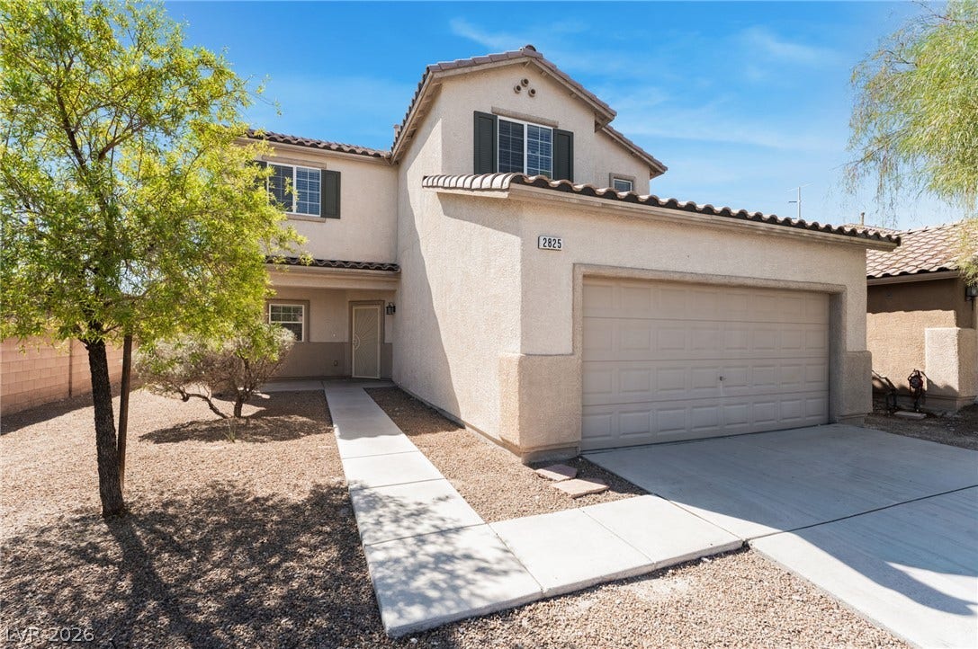 2825 Woodland Park Avenue, North Las Vegas, NV 89086 A concrete walkway leads to the entrance of this multi-level home with tile roofing.