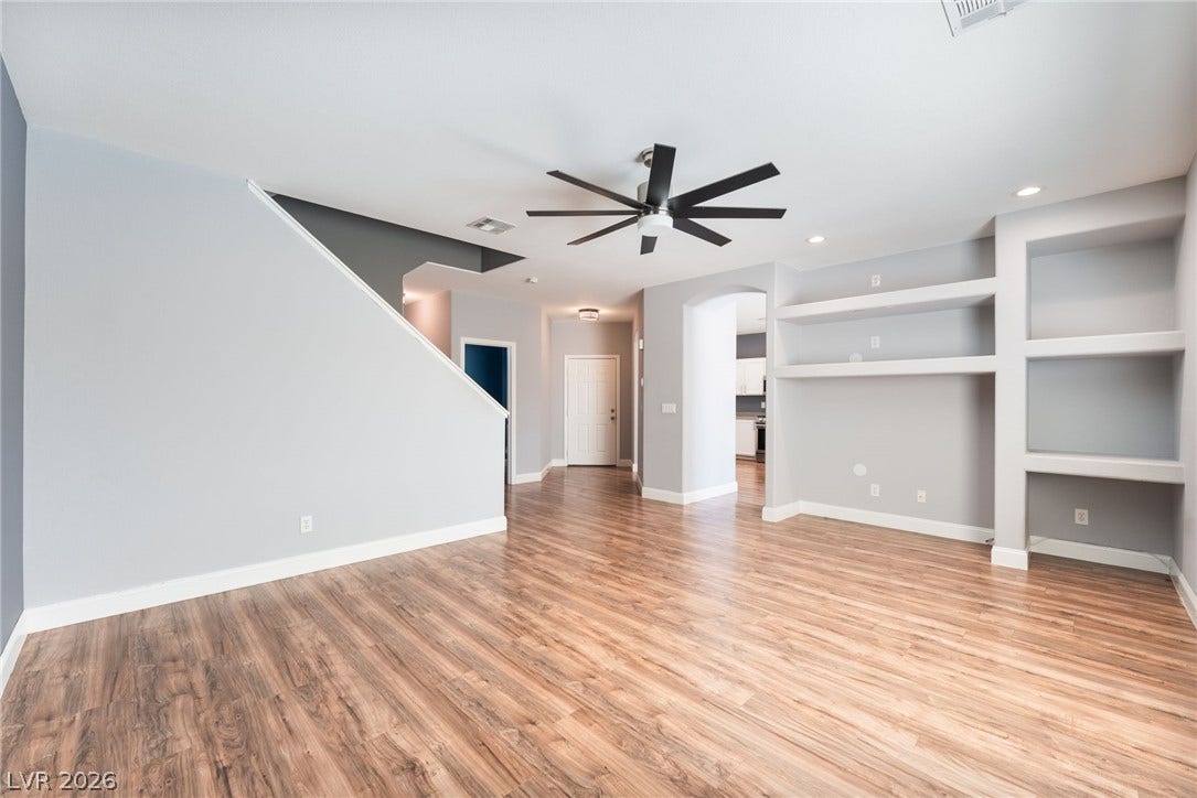2825 Woodland Park Avenue, North Las Vegas, NV 89086 Rich wood flooring runs throughout this spacious living area equipped with custom built-in shelving.