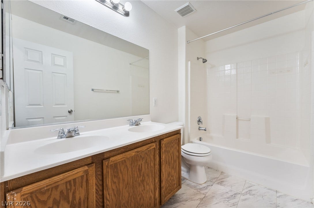 2825 Woodland Park Avenue, North Las Vegas, NV 89086 A spacious double vanity and a classic tub shower highlight this functional bathroom.